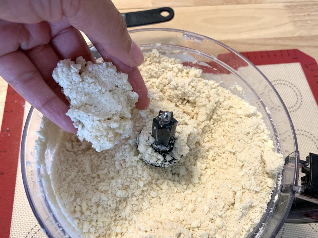 woman holding some pie dough in her hand