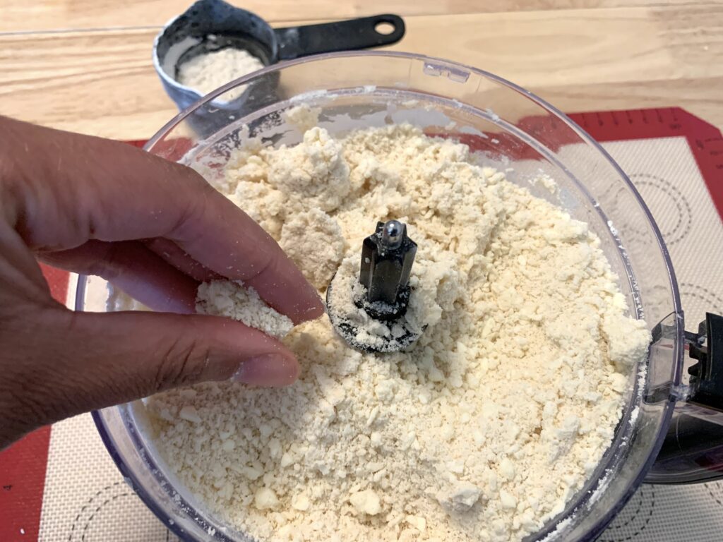 Woman pinching butter double pie dough with fingers